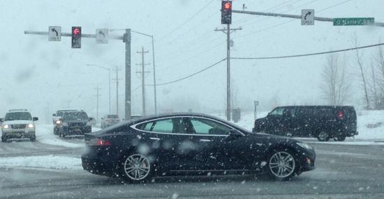 美国阿拉斯加州，一辆在雪天中行驶的特斯拉电动汽车。