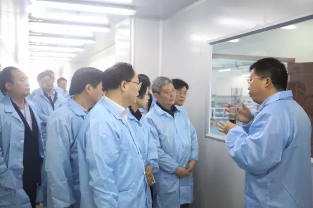 妙盛动力总裁邱则有向湖南副省长张剑飞一行介绍锂电池生产工艺流程