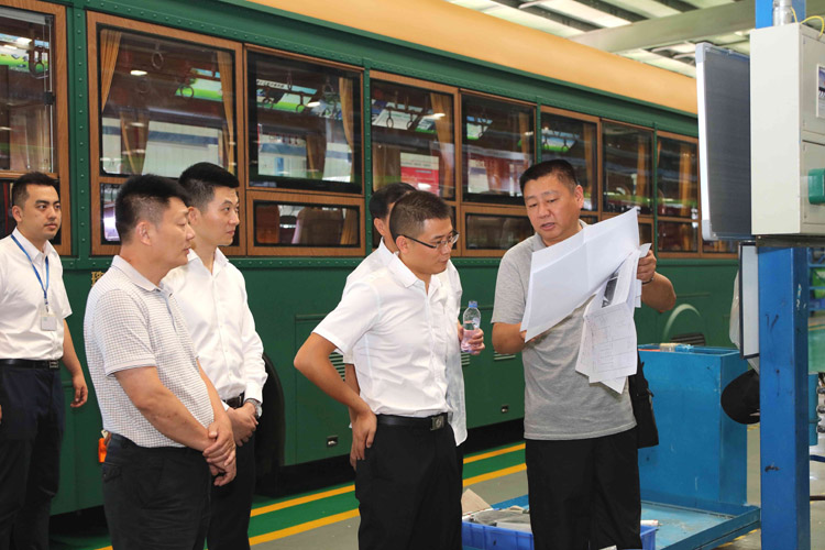 新能源汽车生产现场，领导们对汽车性能与参数作深入咨询