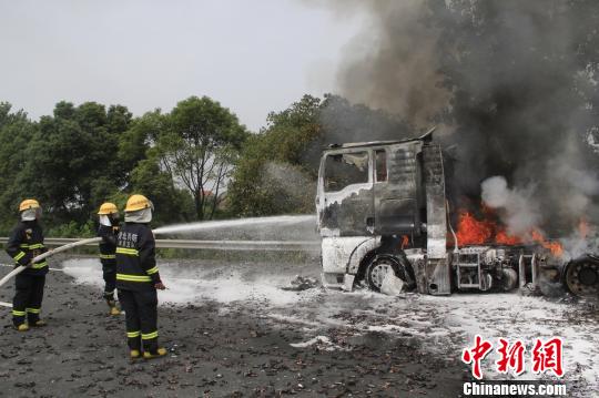摄消防官兵利用泡沫水枪对车头实施扑救。　王基达 摄