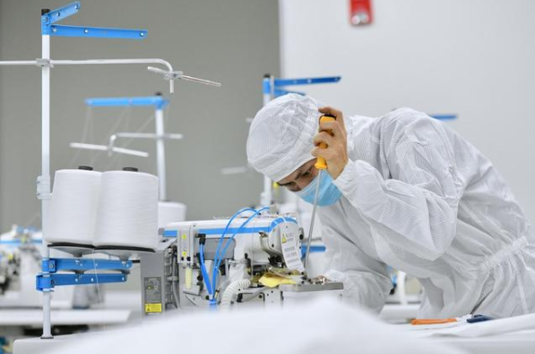 在位于晋江的福建海峡石墨烯产业技术研究院的无菌实验室，技术人员在调试刚刚送达的防护服生产设备。新华社记者姜克红摄